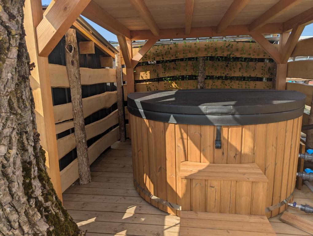 - un kiosque en bois avec un bain à remous sur une terrasse dans l'établissement Un rêve qui devient réalité, à Zilling