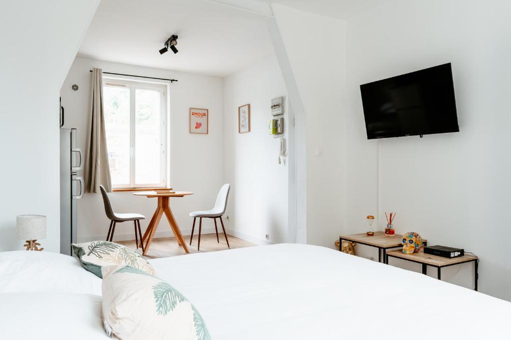 een witte slaapkamer met een bed en een tafel bij Washington 1 in Le Havre