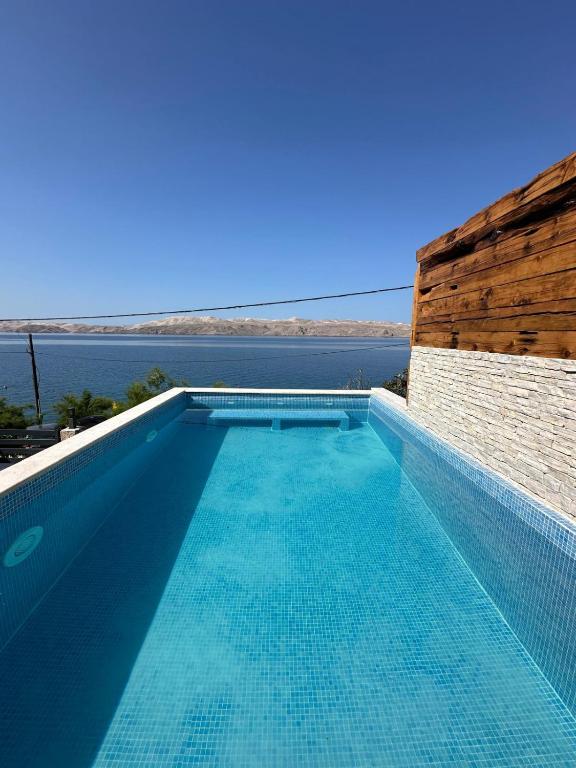 a swimming pool with a view of the ocean at Beachfront Villa Amfora with Pool in Karlobag