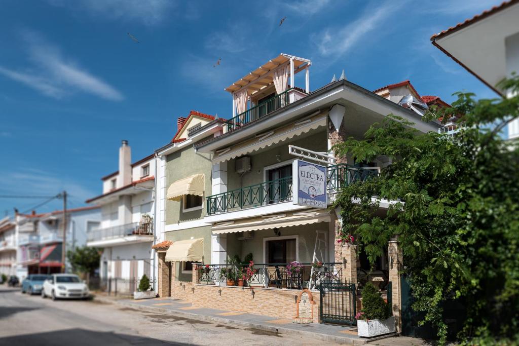 a white building with a balcony on a street at Electra Apartments & Studios 2 in Keramotí