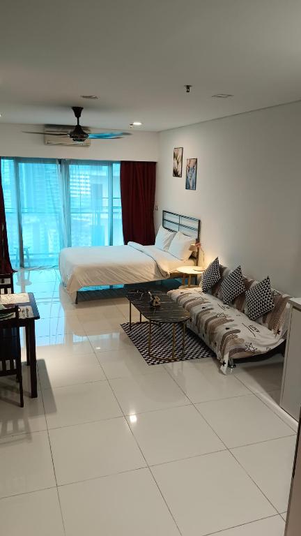 吉隆坡Summer Suites KLCC by CozyNest的一间卧室配有两张床和一张沙发。