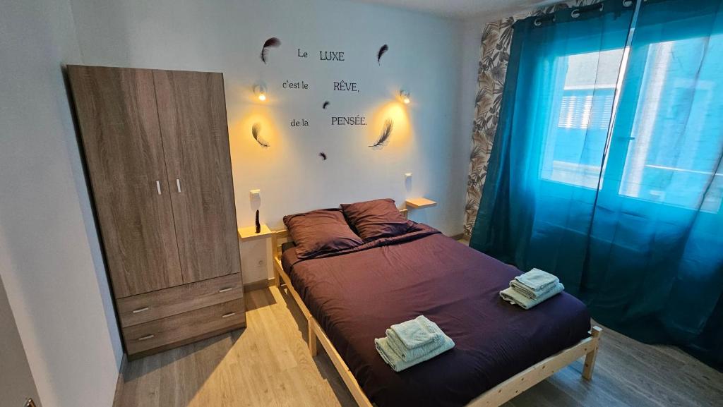 a bedroom with a bed and a wall with writing on the wall at Maison hortensia in Le Cheylard