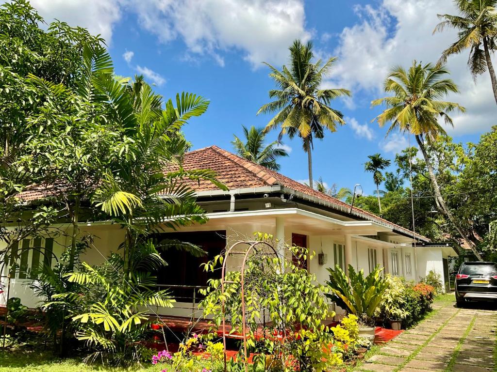une maison avec des palmiers devant dans l'établissement Southern Breeze Homestay Weligama, à Walliwala East