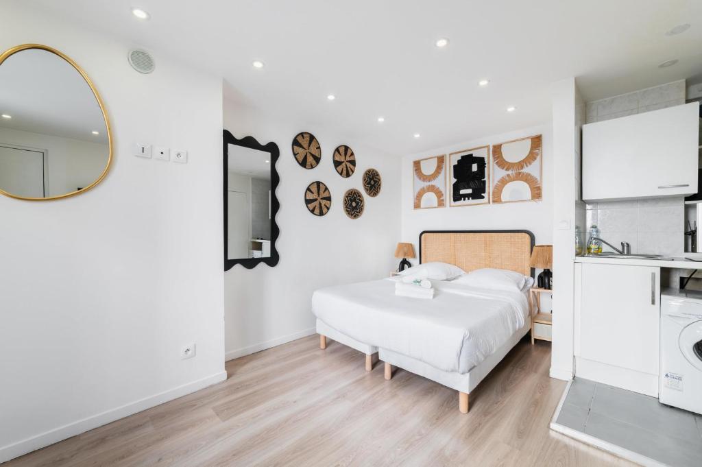 une chambre blanche avec un lit et un miroir dans l'établissement Elegant Studio voltaire- Paris 11 - 2P, à Paris