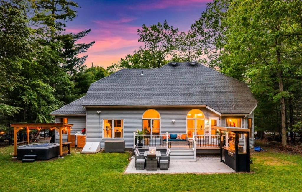 ein kleines Haus mit einer Terrasse und einem Hinterhof in der Unterkunft Dine Outdoors, Dream Indoors 5BR in East Stroudsburg