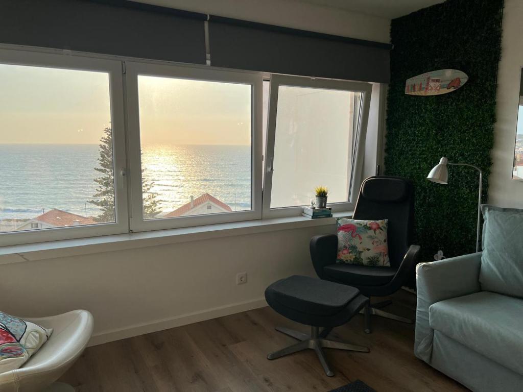 a living room with a chair and two windows at Livelove Sea in Santa Cruz