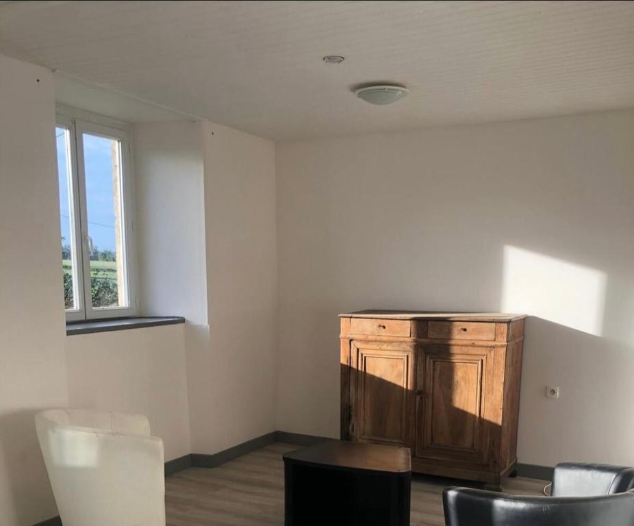 une pièce vide avec une armoire en bois et des chaises dans l'établissement Le rustique, à Souligné-Flacé
