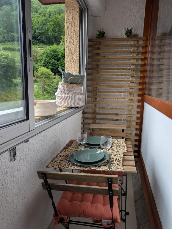 une table avec une assiette dessus dans une fenêtre dans l'établissement Appartement confortable Saint Lary village, à Saint-Lary-Soulan