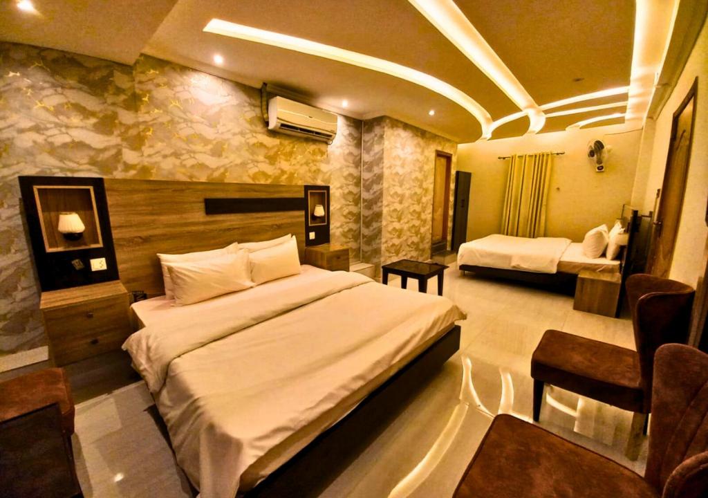 a hotel room with two beds in a room at New Crown Palace Hotel in Islamabad