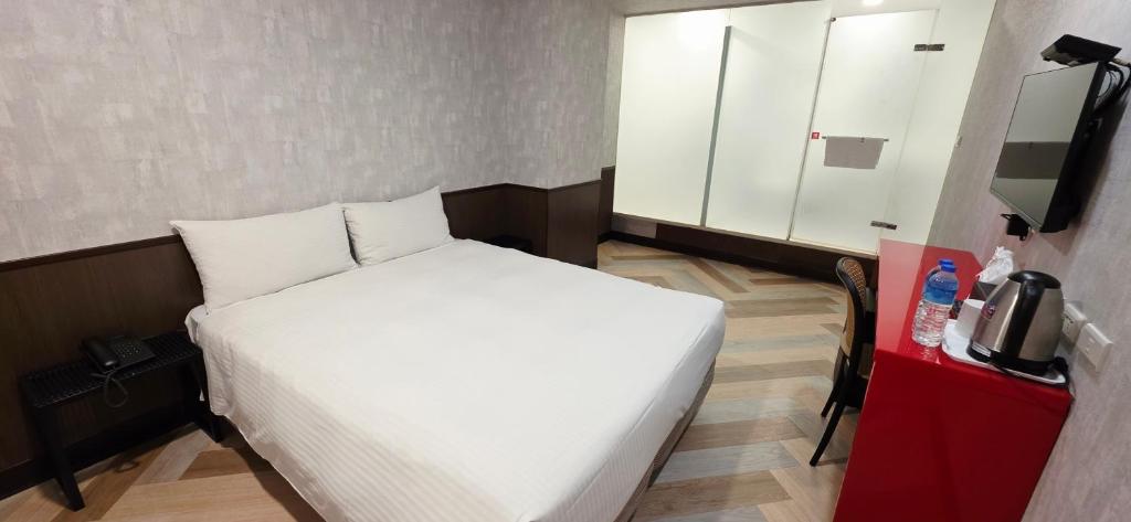 Postel nebo postele na pokoji v ubytování 喜園旅館Ximen Garden Inn