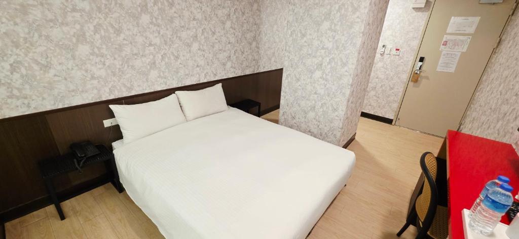 Postel nebo postele na pokoji v ubytování 喜園旅館Ximen Garden Inn