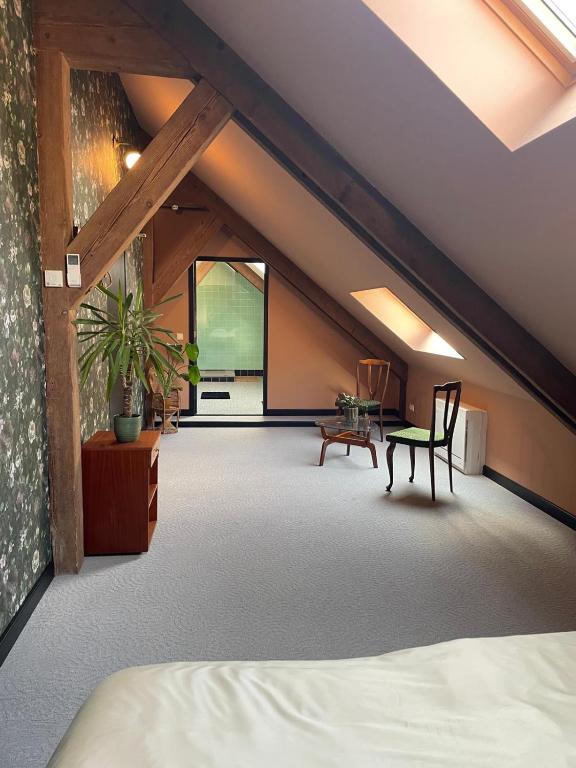 een zolderkamer met een bed en een tafel bij B&B Boudevino in Lekkerkerk