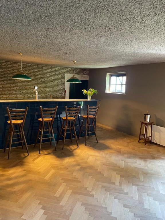 een kamer met een bar met stoelen en een tafel bij B&B Boudevino in Lekkerkerk