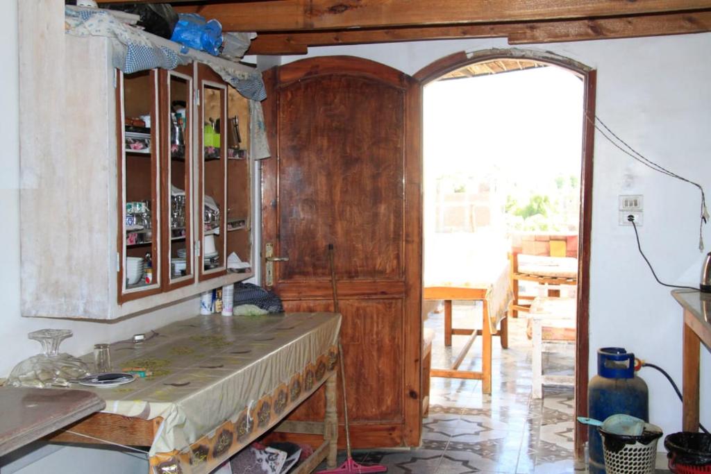 a kitchen with a wooden cabinet in a room at One Love Guesthouse & Restaurant in Luxor