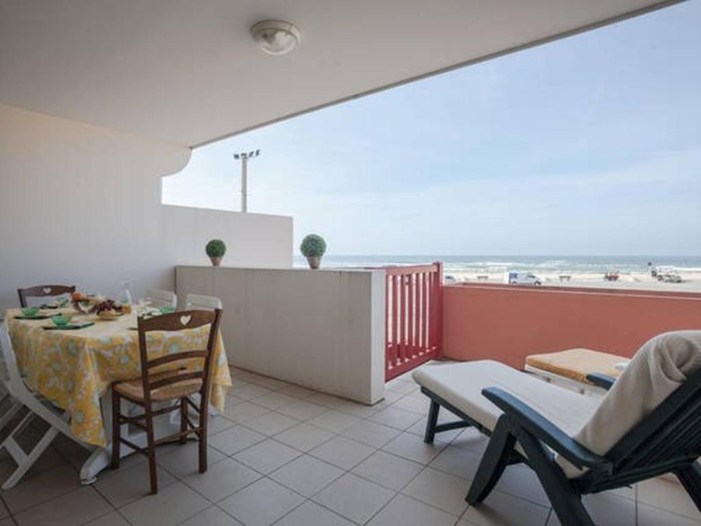 Un balcón con mesa y sillas y el mar. en Appartement T2 cosy avec terrasse et parking à Vieux-Boucau - FR-1-379-65, en Vieux-Boucau-les-Bains