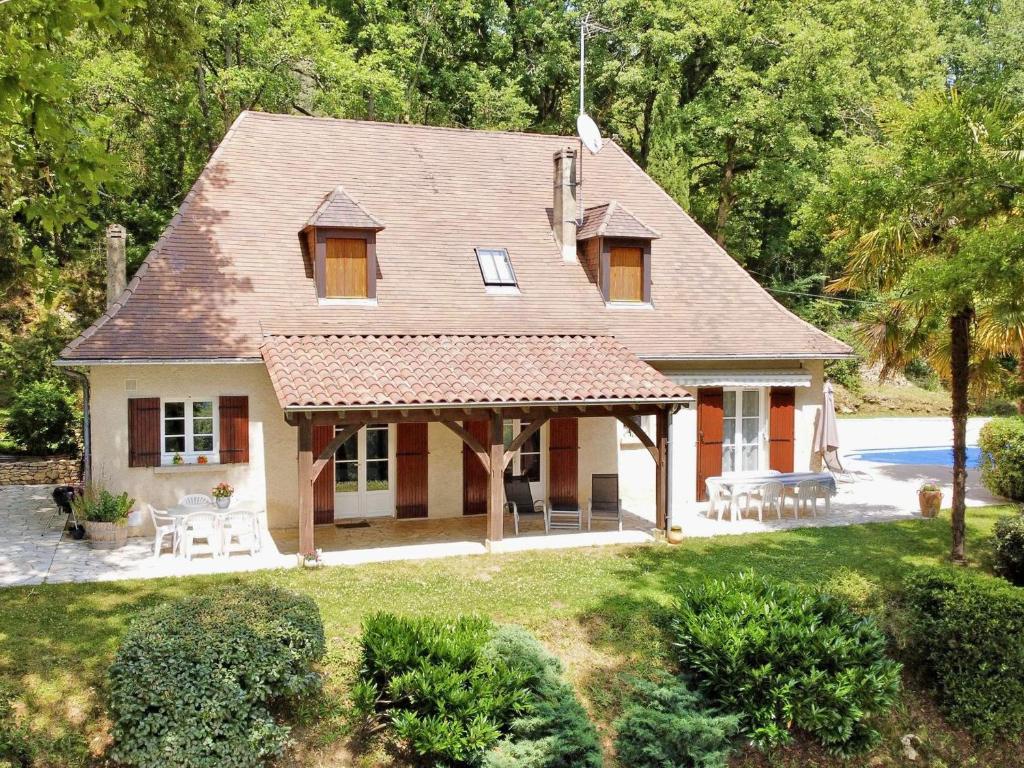 une maison dotée d'un toit avec des tables et des chaises dans l'établissement Charmante maison avec piscine pour 6 personnes à Trémolat - FR-1-824-17, à Trémolat