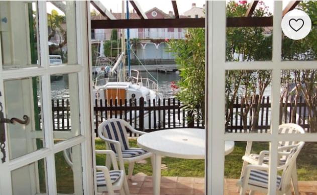 - une vue sur une table et des chaises depuis la fenêtre dans l'établissement appartement avec amarrage bateau jardin port grimaud, à Grimaud