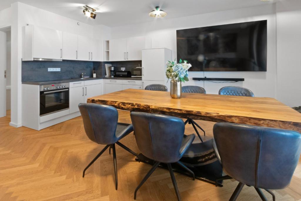 a kitchen with a wooden table and blue chairs at Luxus im Zentrum für 6 Personen! 3 Zimmer, Balkon, WLAN, Parkplatz in Dresden