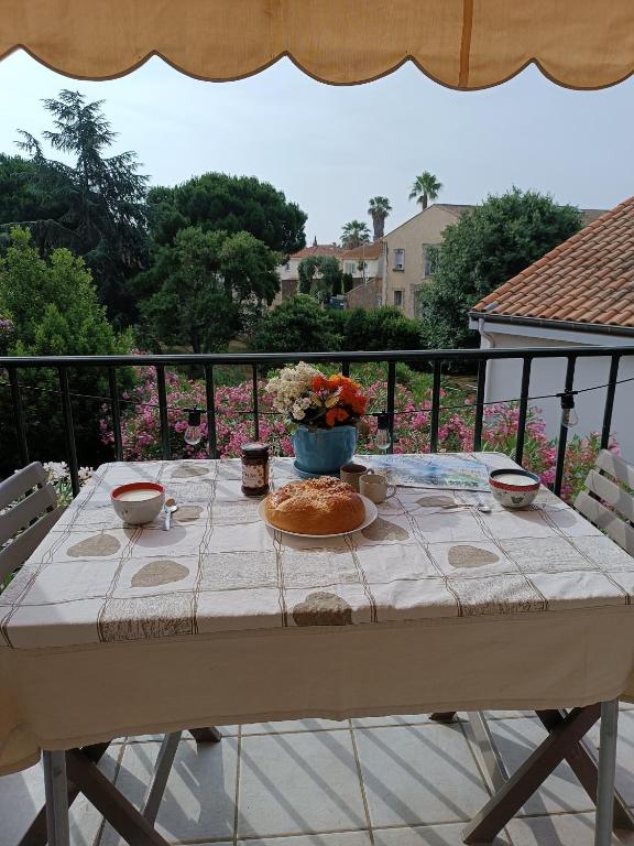 une table avec une assiette de nourriture sur un balcon dans l'établissement Entre Terre et Mer, à Villeneuve-lès-Béziers