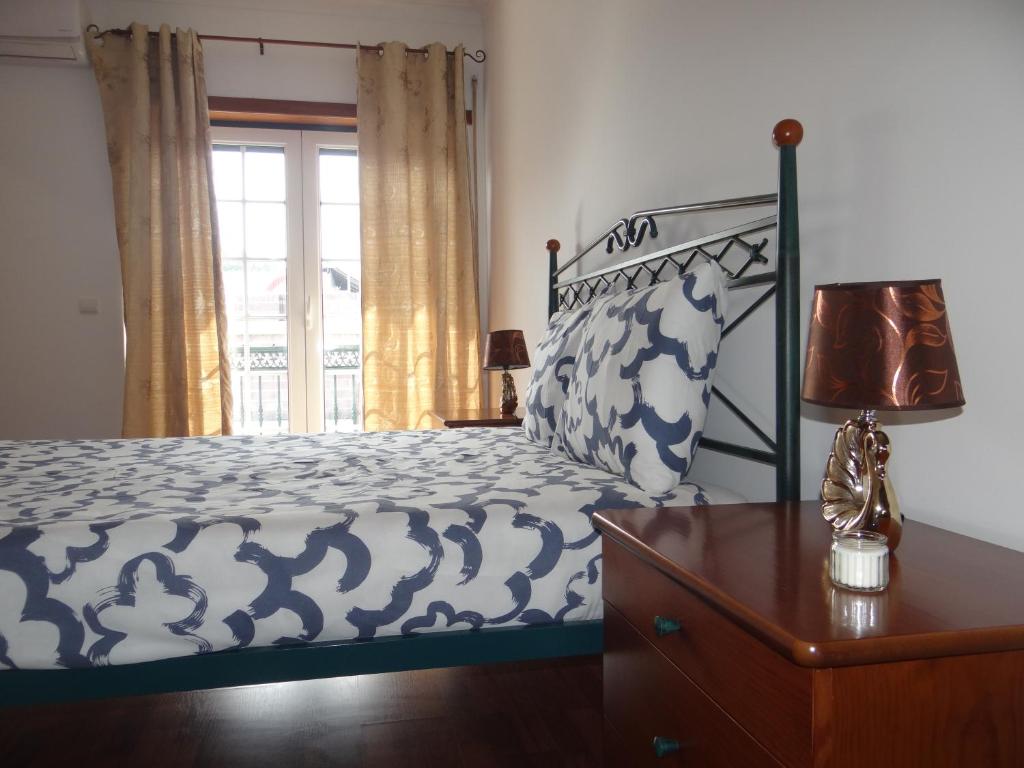 una camera da letto con un letto e una finestra di Quartos, Solar da São a Nazaré