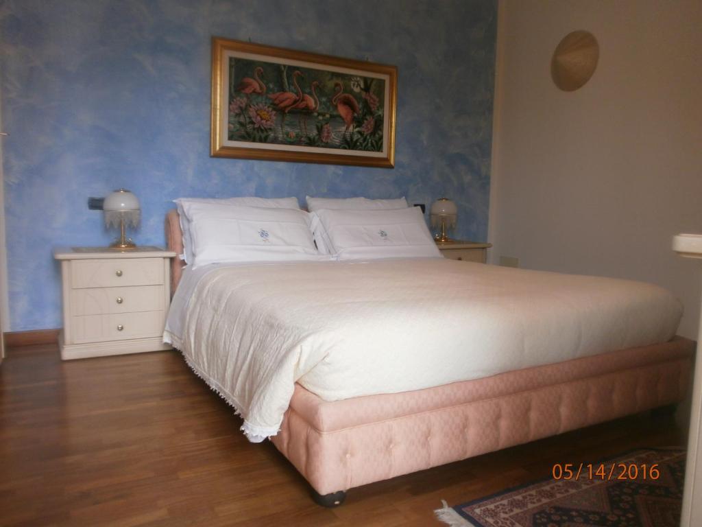 a bedroom with a bed and a painting on the wall at B&B Dosso Quarel in Costermano