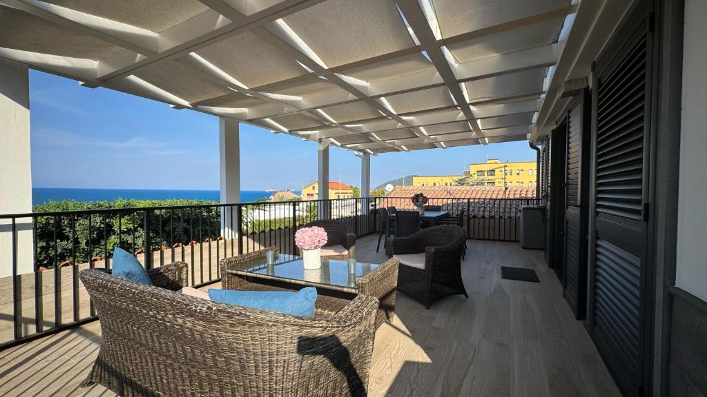 eine Terrasse mit Stühlen und einem Tisch auf einem Balkon in der Unterkunft SAN - Luxury Apartment in Santa Maria di Castellabate