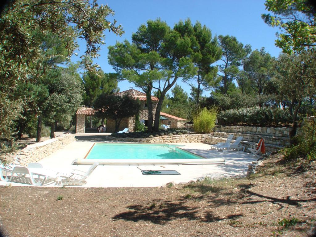 une piscine avec des chaises et une maison dans l'établissement Mas provençal - Beautiful Provencal farmhouse, heated pool, à Murs