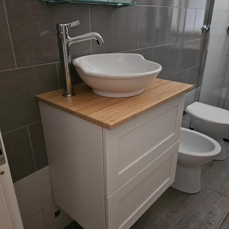 une salle de bain avec un lavabo et des toilettes dans l'établissement Via Genova, à La Caletta
