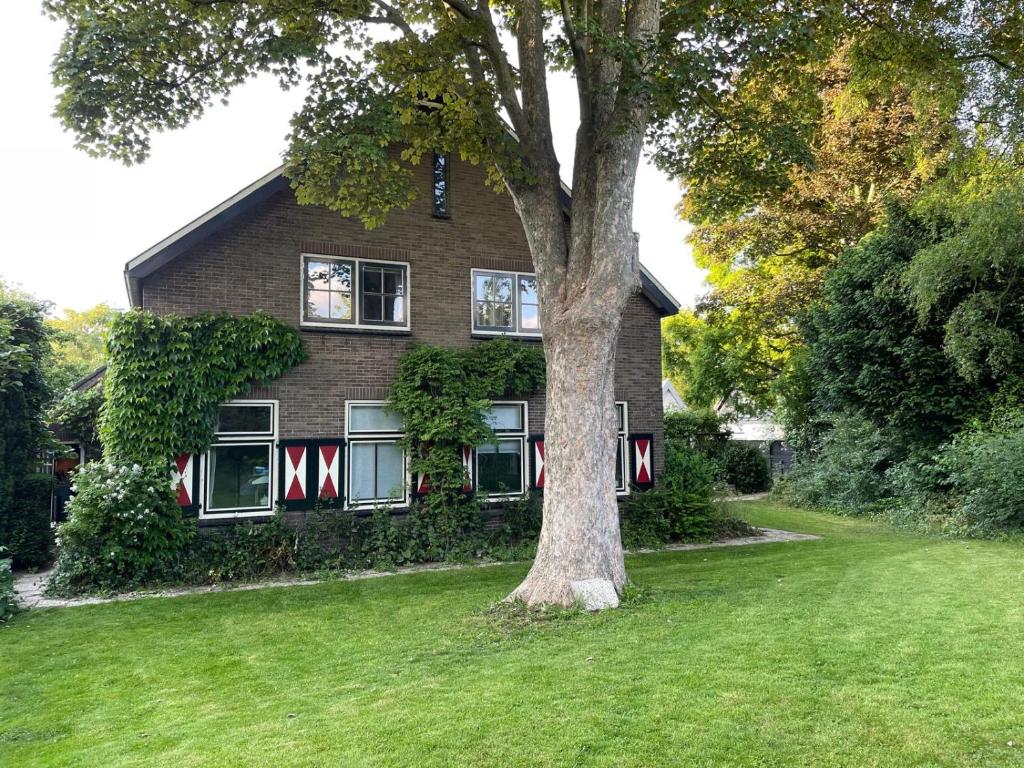 een huis met een boom ervoor bij B&B Boudevino in Lekkerkerk