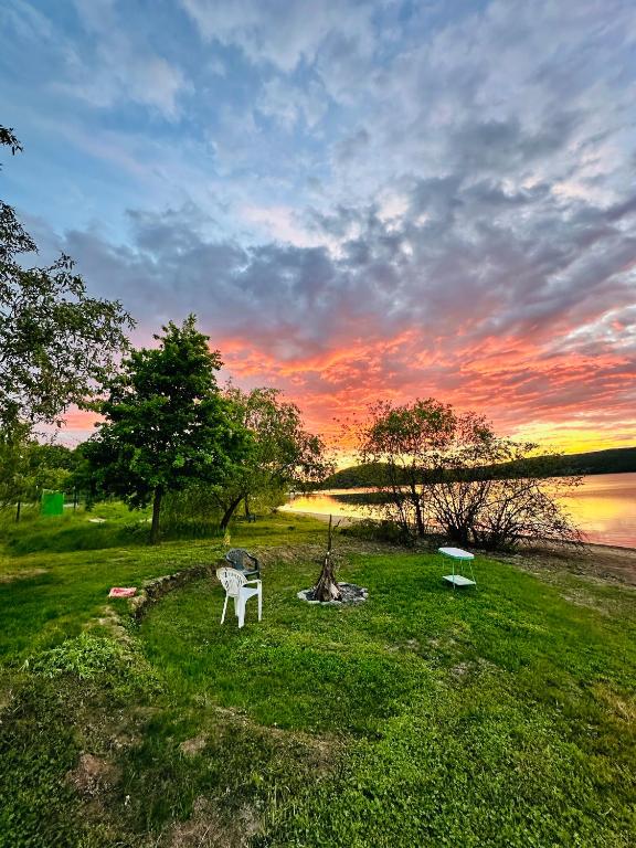 a park with a bench and a fire hydrant at sunset at Casa de vacanta 483A, Lacul Surduc in Fîrdea
