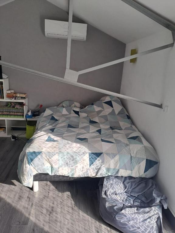 une chambre avec un lit avec un oreiller géométrique dans l'établissement Chambres proche gare centre ville, au Mans