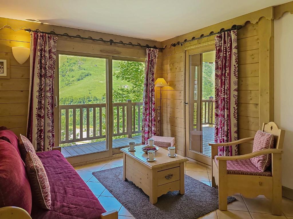d'un salon avec un canapé et un balcon. dans l'établissement La Croix des Vallées - Proche des pistes des Ménuires, aux Menuires