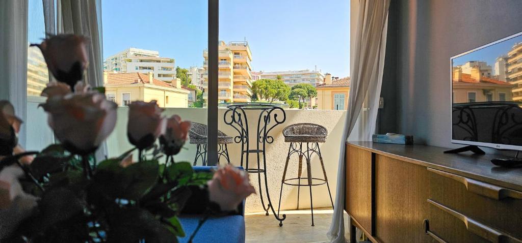 un salon avec une télévision et un balcon avec une table dans l'établissement Cannes Côte d'Azur Sea View Air Conditioning Beach Apartment, à Cannes