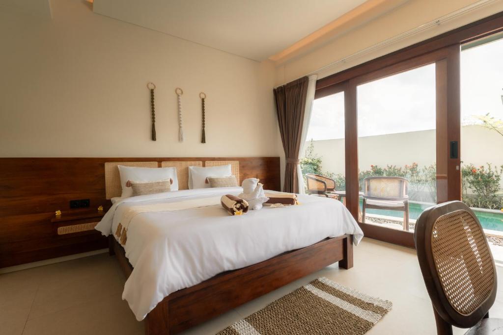 a bedroom with a large bed and a large window at Rasa Ubud Yoga Coliving in Ubud