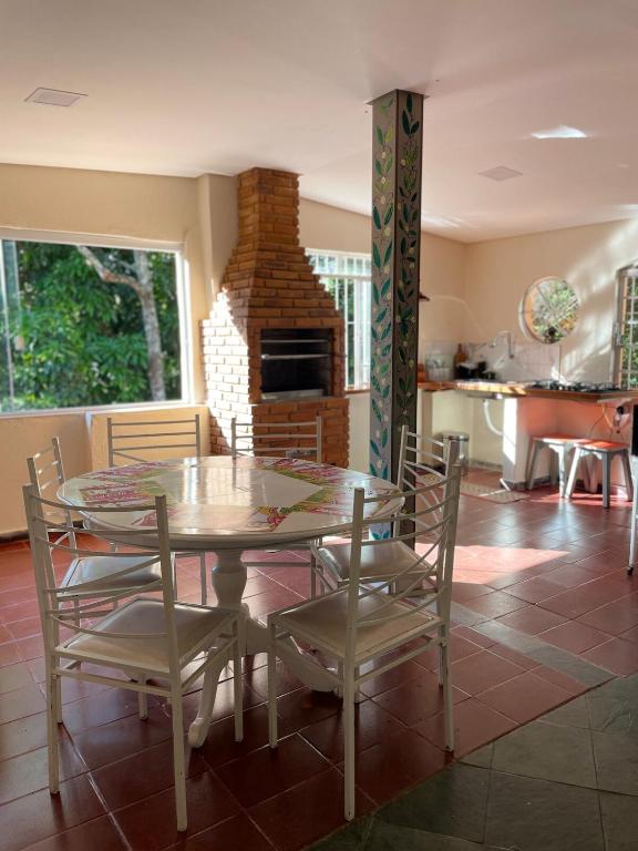 a dining room with a table and chairs and a fireplace at Recanto Verde in Conceição dos Ouros