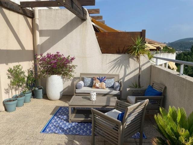 un patio avec un canapé, une table et des chaises dans l'établissement Adélice, à Hyères