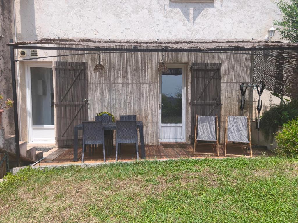 - un groupe de chaises et une table sur une terrasse couverte dans l'établissement Chez LINAT - Studio en rez de jardin au calme avec vue mer, à Vallauris