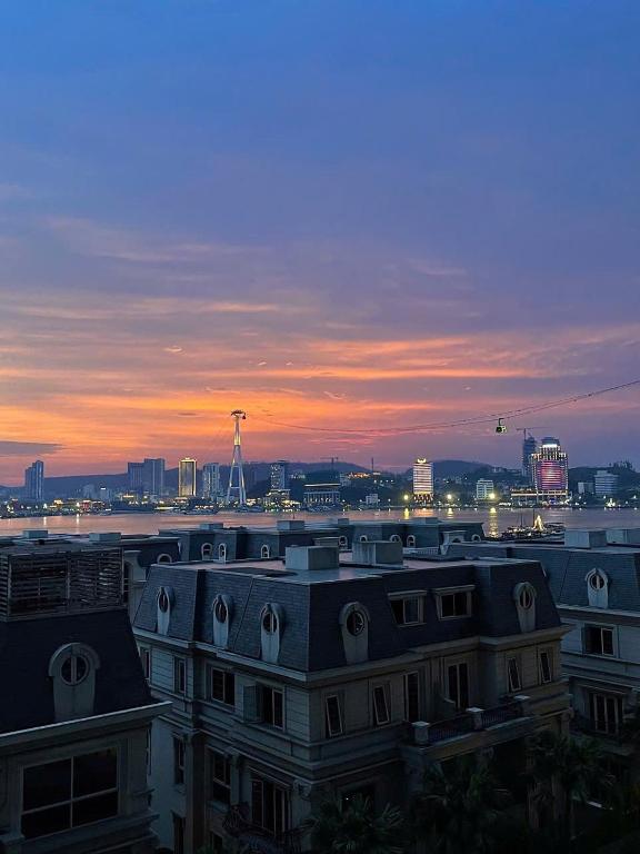 a view of a building with a sunset in the background at Studio Sapphire Hạ Long View Biển in Ha Long