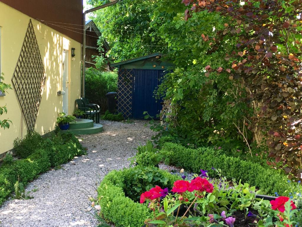 a garden with flowers and a blue door at Villa Musica in Aschau im Chiemgau