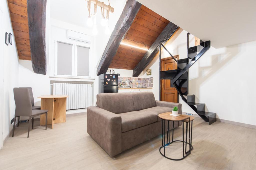a living room with a couch and a staircase at Appartamento nel cuore di Torino in Turin