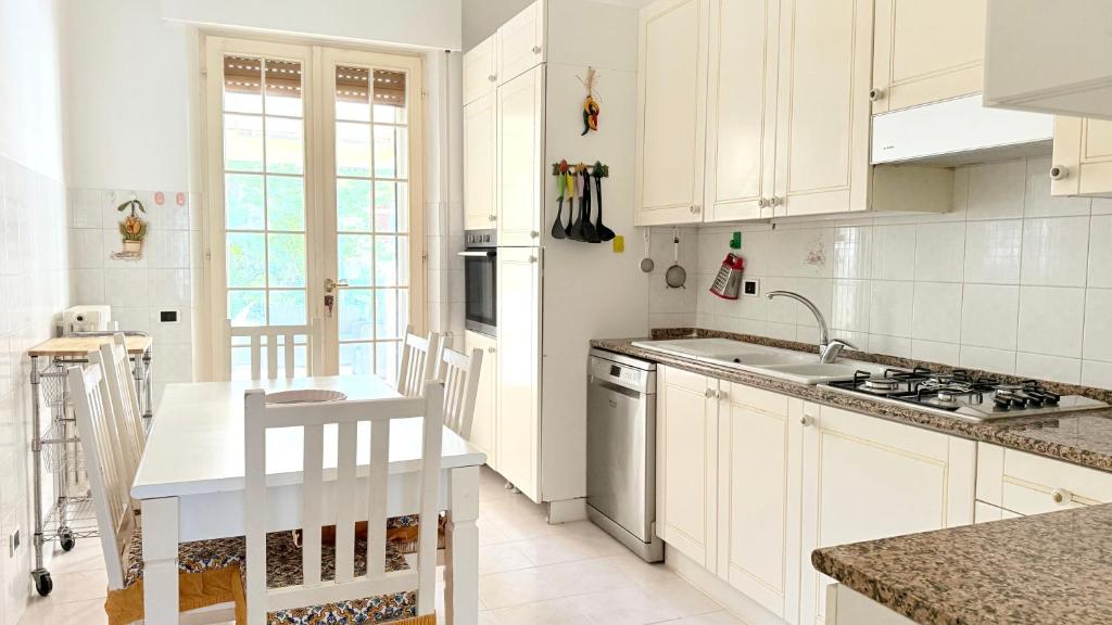 a kitchen with white cabinets and a sink and a stove at S353 - Sirolo, ampio quadrilocale accessoriato con giardino in Sirolo