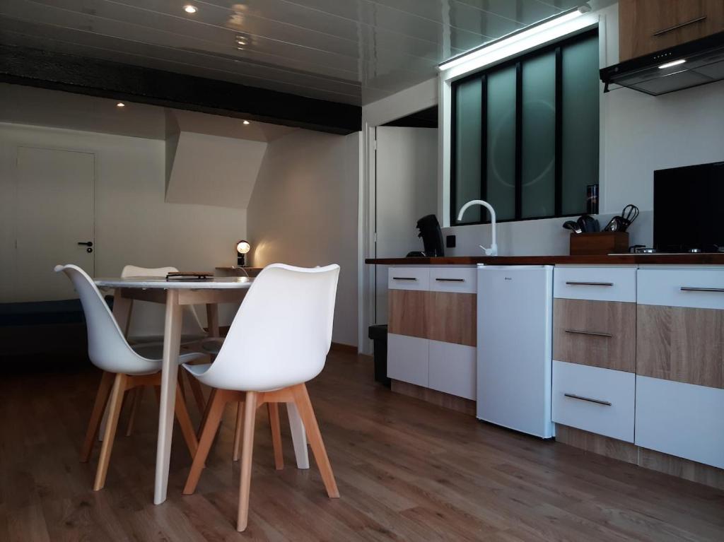 - une cuisine avec des chaises blanches, une table et un évier dans l'établissement Stay zen Studio, à Marquay