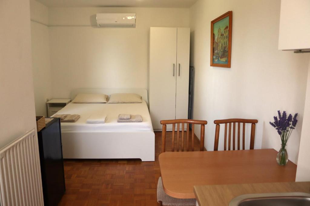 une petite pièce avec un lit, une table et des chaises dans l'établissement Apartments Cipresa, à Portorož