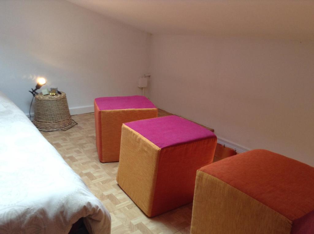 a room with three ottomans and three stools at Chinchon in LʼIsle-sur-la-Sorgue
