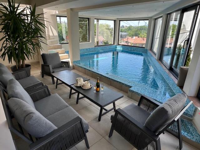 a large swimming pool with a table and chairs at Apel Luxury in Niš