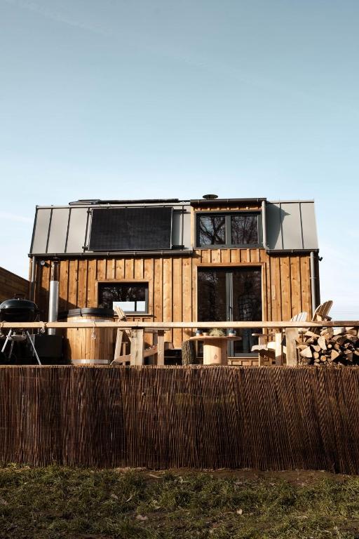 une maison construite sur une clôture en bois dans l'établissement Le Refuge Du Maraicher, 