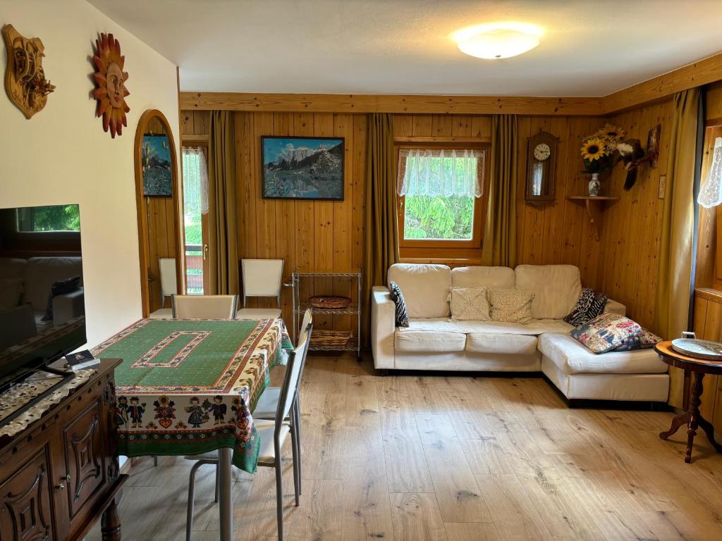 een woonkamer met een bank en een tafel bij Mes Lastei in Campitello di Fassa