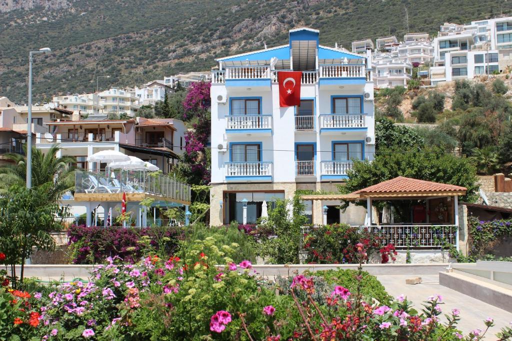 ein weißes Gebäude mit einem roten Kreuz darauf in der Unterkunft Kelebek Hotel in Kalkan