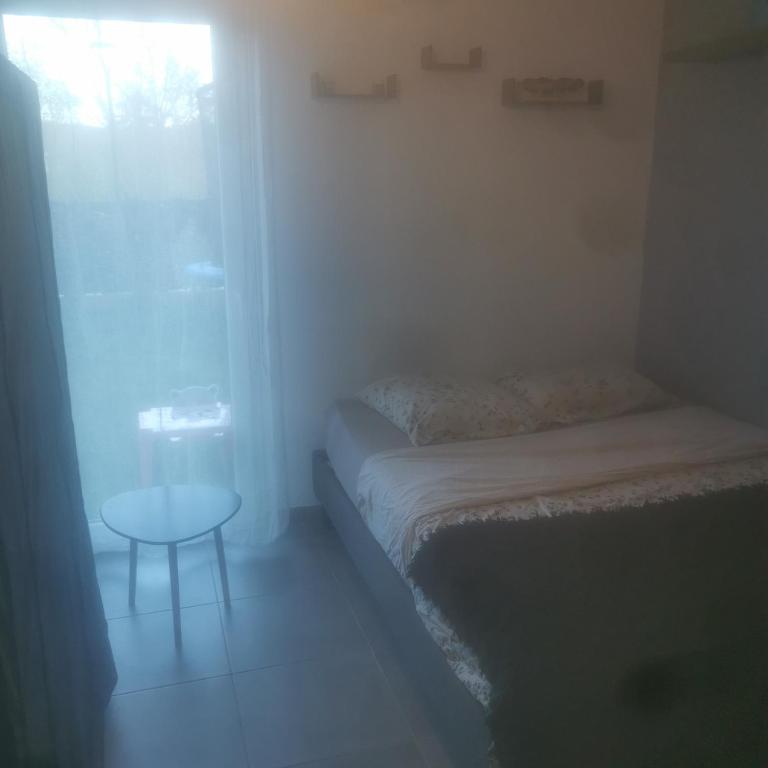 une petite pièce avec un lit et une table dans l'établissement 3 pièces avec jardin, à Fréjus