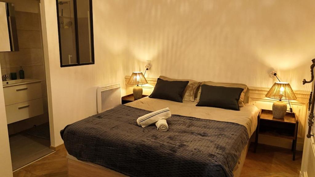 une chambre avec un grand lit avec deux lampes dans l'établissement CHARME 1850, climatisé et cinéma, à Montpellier